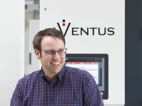 AVENTUS-Mitarbeiter vor einer AVENTUS Verpackungsmaschine in der Produktionshalle