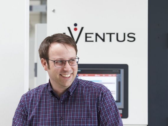 AVENTUS-Mitarbeiter vor einer AVENTUS Verpackungsmaschine in der Produktionshalle